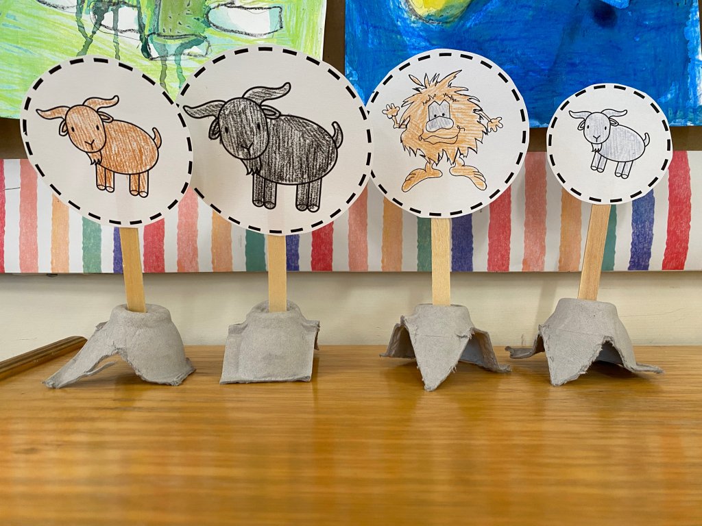 An image of four puppets made of printed animals attached to popsicle sticks